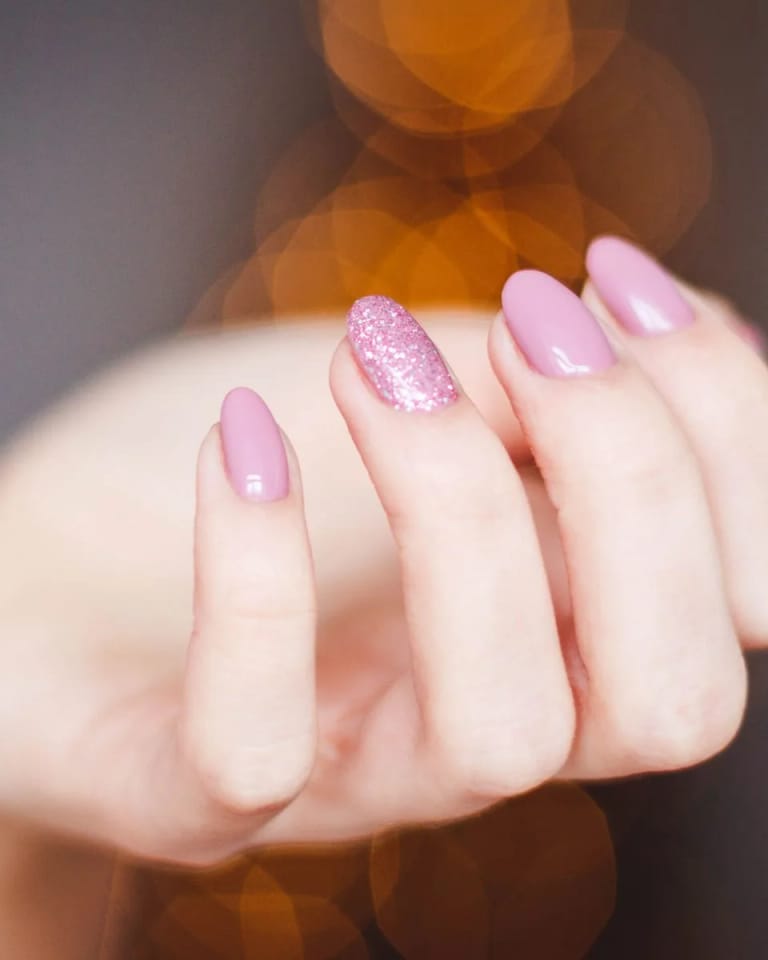Uñas rosa empolvado con brillo glossy y un destello de glitter