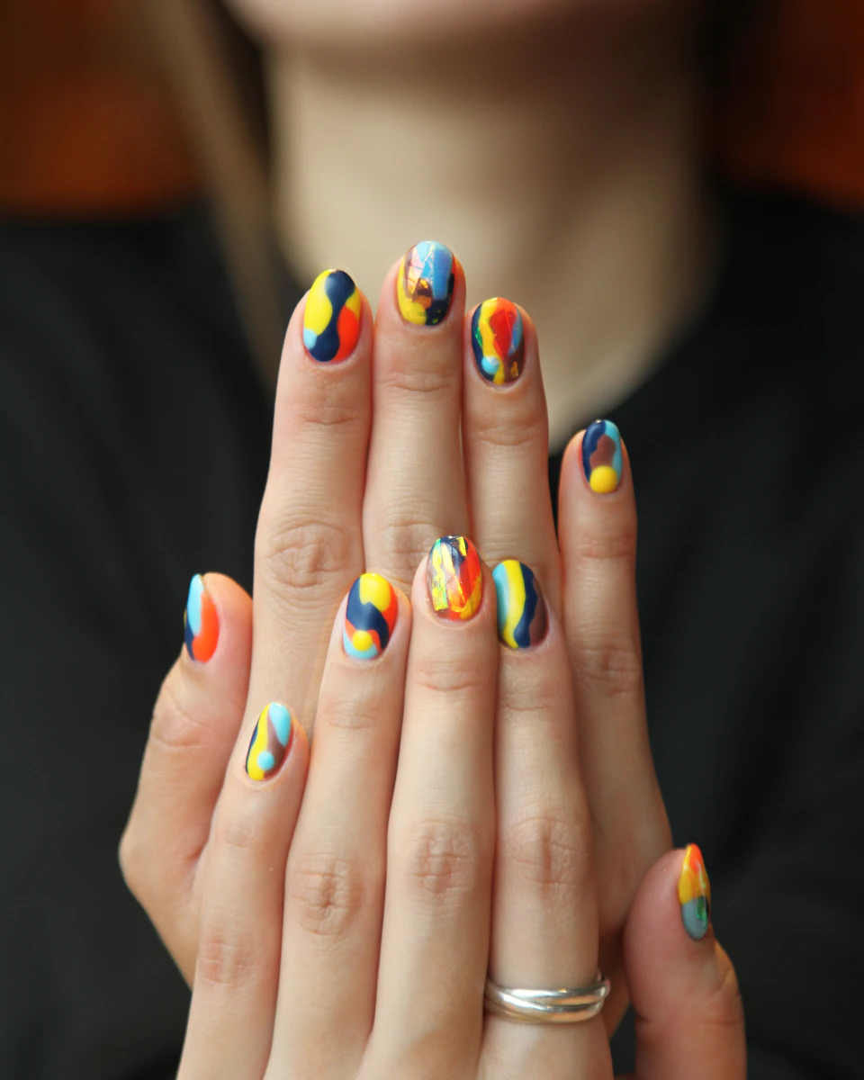 Nail art multicolor con pinceladas abstractas en ambas manos