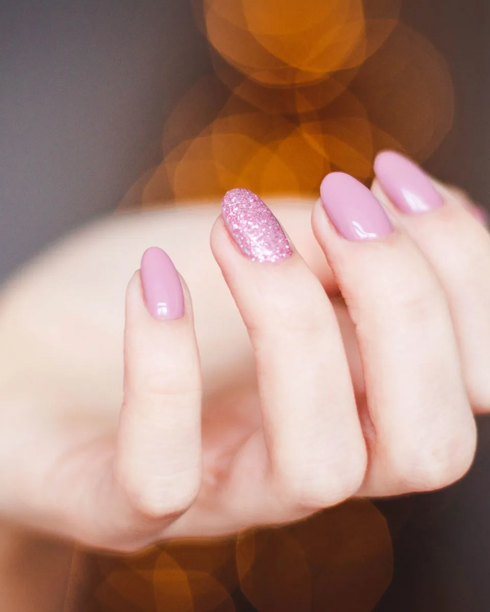 Uñas rosa empolvado con brillo glossy y un destello de glitter